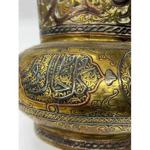 393 - An Islamic vase, the brass vessel is inlaid with copper and Arabic calligraphy (H17cm Dia15cm)