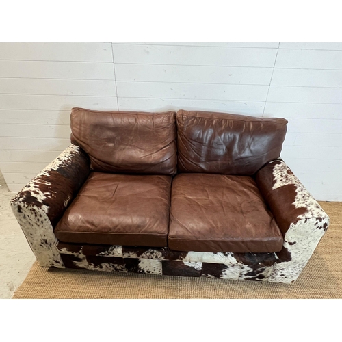 4 - A two seater leather and cow hide sofa (H84cm 175cm D95cm SH41cm)