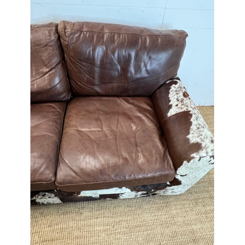 4 - A two seater leather and cow hide sofa (H84cm 175cm D95cm SH41cm)