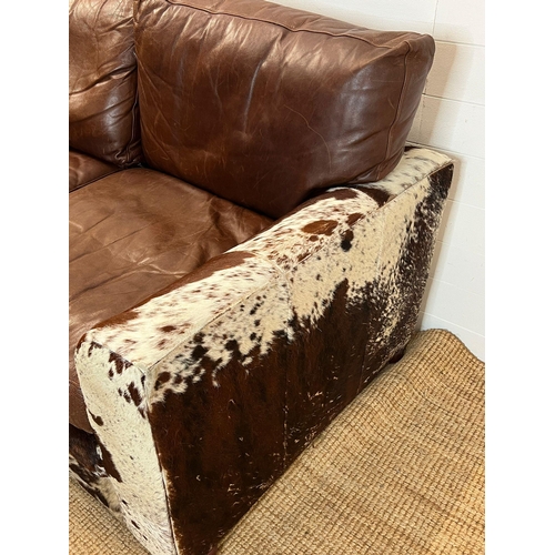 4 - A two seater leather and cow hide sofa (H84cm 175cm D95cm SH41cm)