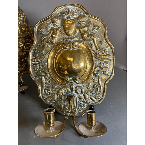 402 - A pair of brass wall sconce, cast backplate with winged cherubs and twin arm candle holders