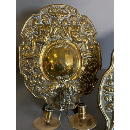 402 - A pair of brass wall sconce, cast backplate with winged cherubs and twin arm candle holders