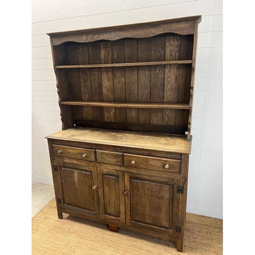 42 - A rustic oak dresser, Plate rack sits on a base comprising of drawers and cupboards (H193cm W138cm D... 