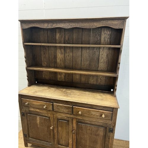 42 - A rustic oak dresser, Plate rack sits on a base comprising of drawers and cupboards (H193cm W138cm D... 