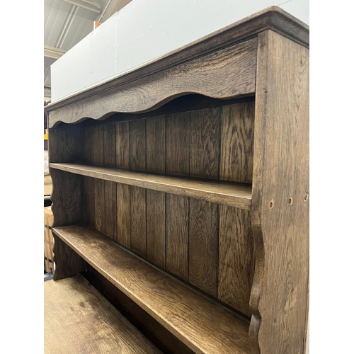 42 - A rustic oak dresser, Plate rack sits on a base comprising of drawers and cupboards (H193cm W138cm D... 