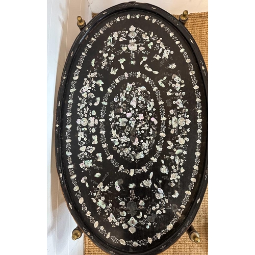 422 - An oval oriental ebony tray with a floral mother of pearl inlay on stand 84cm x 52cm