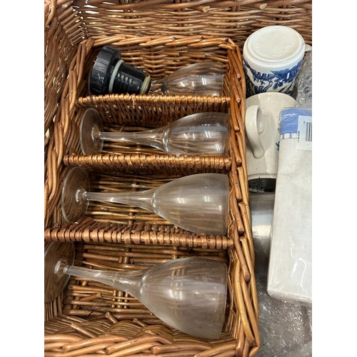 445 - A wicker picnic basket comprising of blue and white plates, cutlery, thermos and plastic glasses