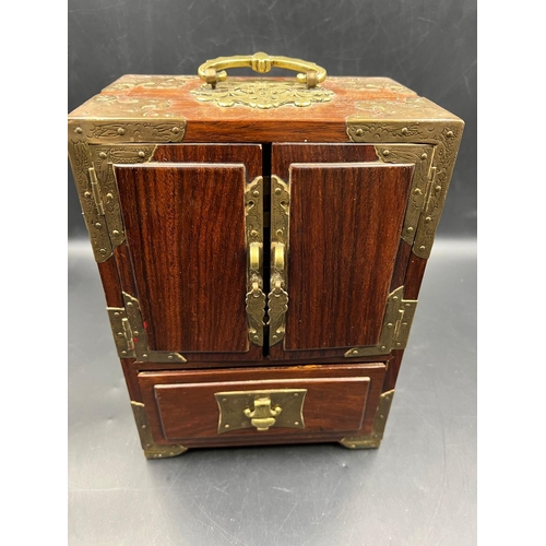 451 - An Oriental themed jewellery box in hardwood with brass decoration. (23.5cm H x 17cm W x 11cm D)