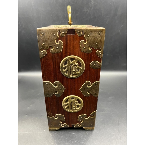 451 - An Oriental themed jewellery box in hardwood with brass decoration. (23.5cm H x 17cm W x 11cm D)