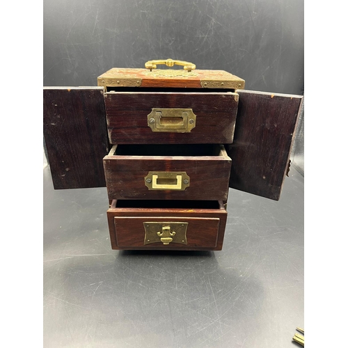 451 - An Oriental themed jewellery box in hardwood with brass decoration. (23.5cm H x 17cm W x 11cm D)