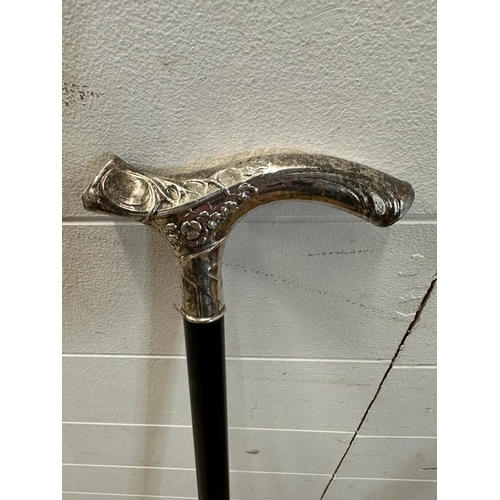 454 - A black painted walking cane with an Art Deco style white metal handle