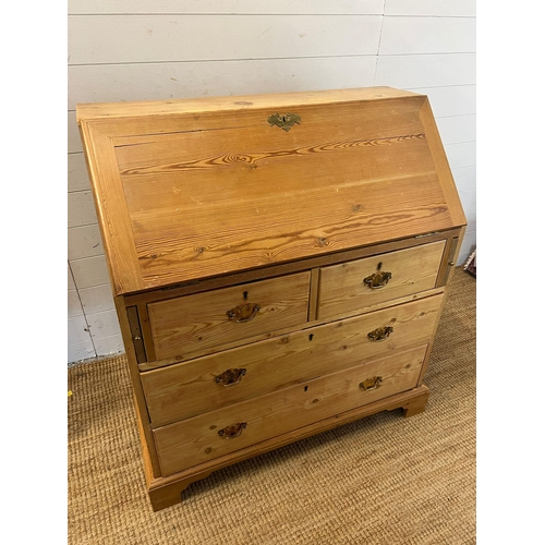 57 - A pine bureau with brass handles and drop down writing slope (H105cm W93cm D47cm)