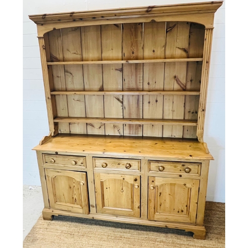 59 - A pine dresser with three shelve plate rack sat upon a three drawer over three cupboard base (H211cm... 