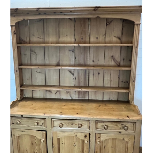 59 - A pine dresser with three shelve plate rack sat upon a three drawer over three cupboard base (H211cm... 