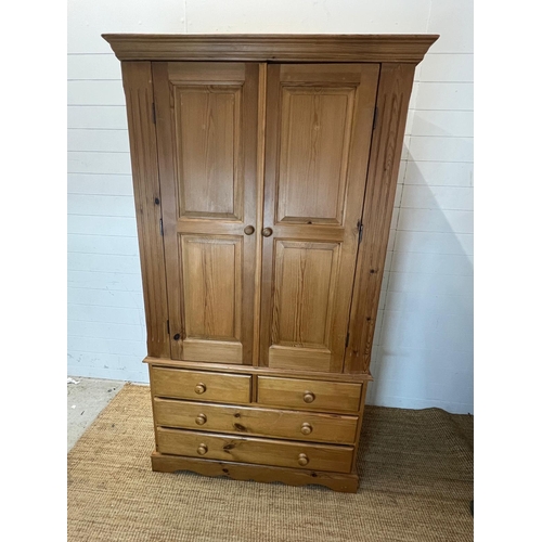 61 - A pine wardrobe sat on a drawer base (H193cm W110cm D62cm)