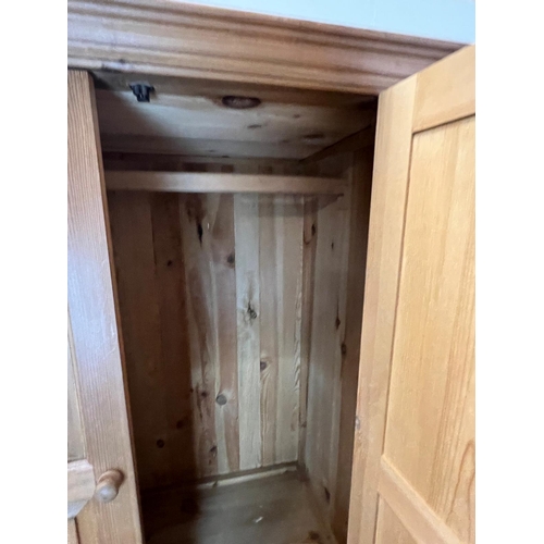 61 - A pine wardrobe sat on a drawer base (H193cm W110cm D62cm)