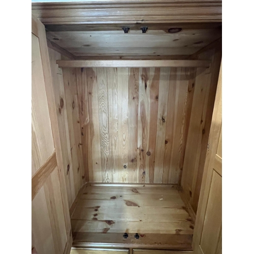 61 - A pine wardrobe sat on a drawer base (H193cm W110cm D62cm)