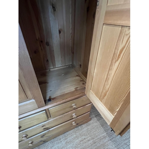 61 - A pine wardrobe sat on a drawer base (H193cm W110cm D62cm)