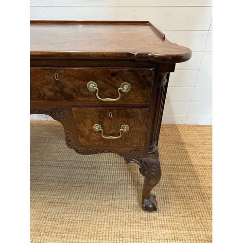 94 - a Georgian style walnut knee hole desk with brass drop handles and galleried top on claw and ball fe... 