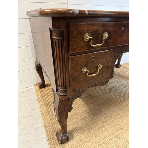 94 - a Georgian style walnut knee hole desk with brass drop handles and galleried top on claw and ball fe... 