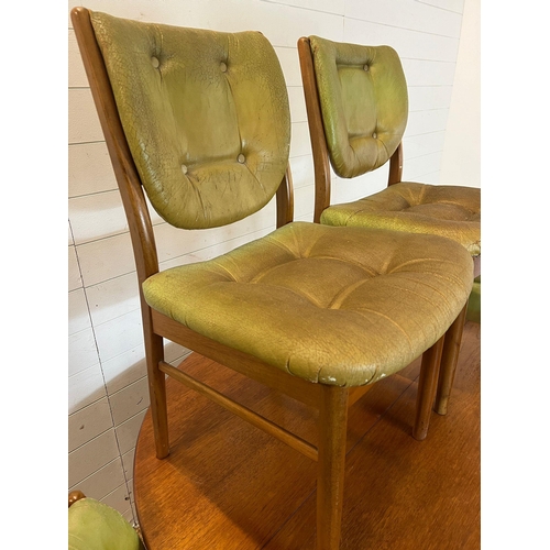 101 - A Mid Century teak circular extending table with four balloon back chairs (H73cm W120cm)