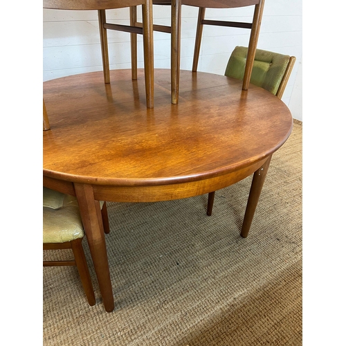 101 - A Mid Century teak circular extending table with four balloon back chairs (H73cm W120cm)