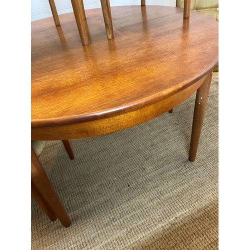 101 - A Mid Century teak circular extending table with four balloon back chairs (H73cm W120cm)