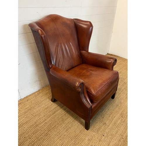 102 - A leather wing back chair