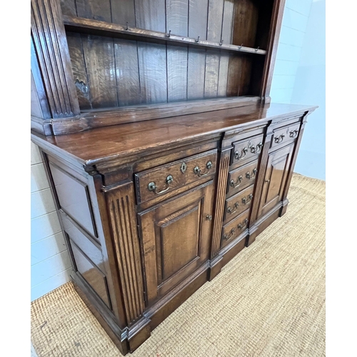 133 - An oak dresser with large plate rack sat on a cupboard base and drop handle (H208cm W177cm D55cm)