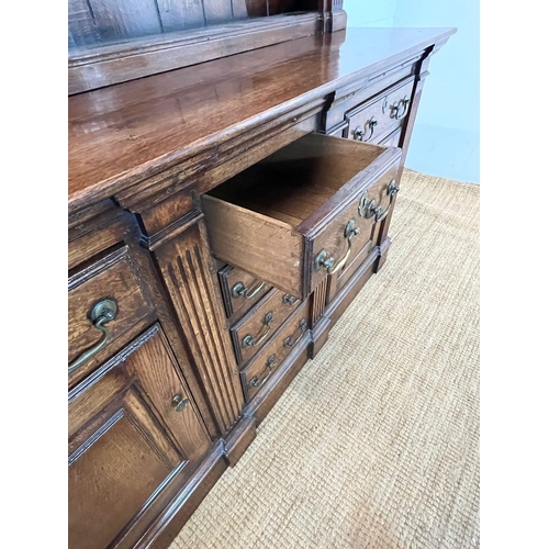 133 - An oak dresser with large plate rack sat on a cupboard base and drop handle (H208cm W177cm D55cm)