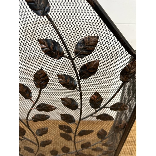 139 - A wrought iron and wire mesh fire guard with leaf details