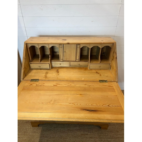 145 - A pine bureau with brass handles and drop down writing slope (H105cm W93cm D47cm)