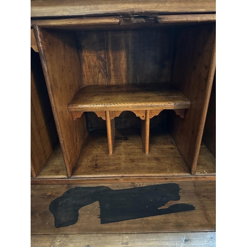 149 - A large pine bureau. The front fall opening to pigeon holes, drawers and a brown leather topped writ... 