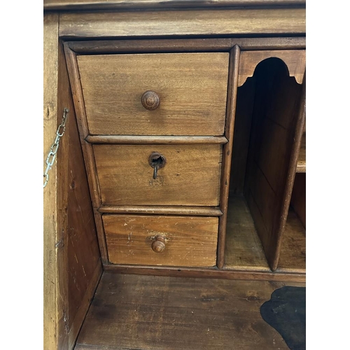 149 - A large pine bureau. The front fall opening to pigeon holes, drawers and a brown leather topped writ... 