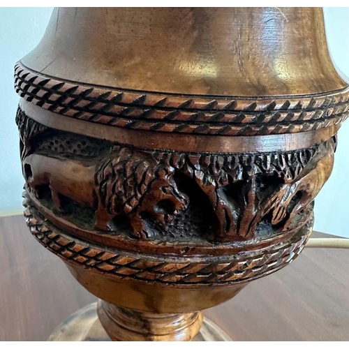 198 - An African style wooden carved table lamp with a lion banded relief