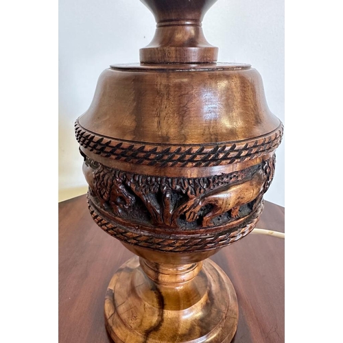 198 - An African style wooden carved table lamp with a lion banded relief