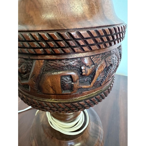 199 - An African style wooden carved table lamp with a tribal banded relief