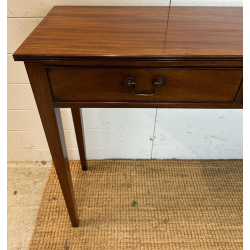 20 - A mahogany three drawer console table with brass drop handles (H77cm W138cm D32cm)