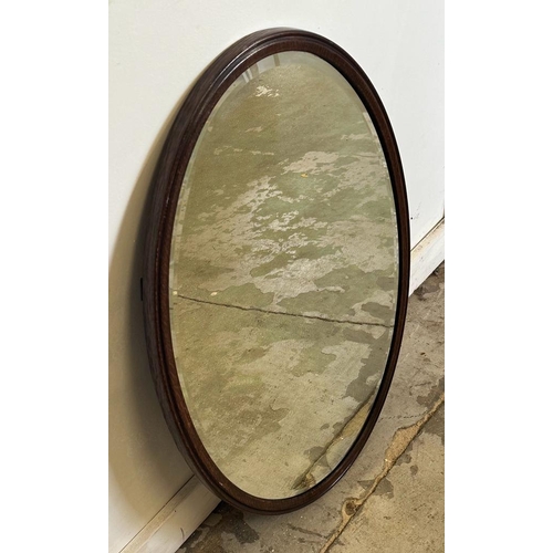 208 - An oval mahogany framed bevel edged hall mirror 80cm x 54cm