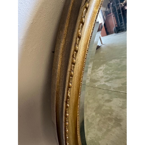 209 - A gold painted oval hall mirror with bevelled edge 84cm x 59cm