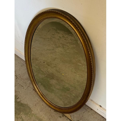 209 - A gold painted oval hall mirror with bevelled edge 84cm x 59cm