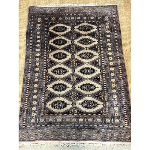 215 - A Pakistani style geometric tug, twelve diamond motifs to centre 180cm x 125cm