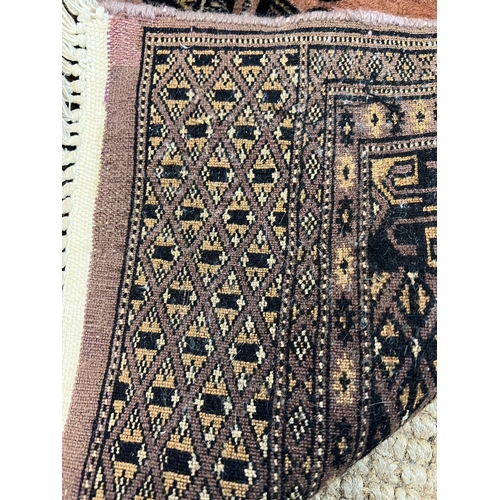 218 - A Pakistani style geometric rug with one central motif with pink grounds 105cm x 95cm