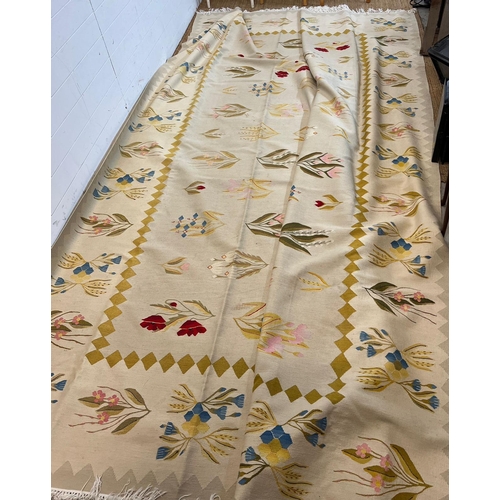 219 - A large embroidery rug with cream grounds and floral stemmed flowers 380cm x 285cm