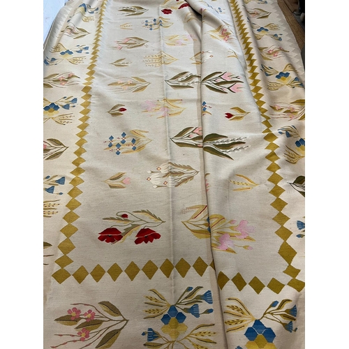 219 - A large embroidery rug with cream grounds and floral stemmed flowers 380cm x 285cm