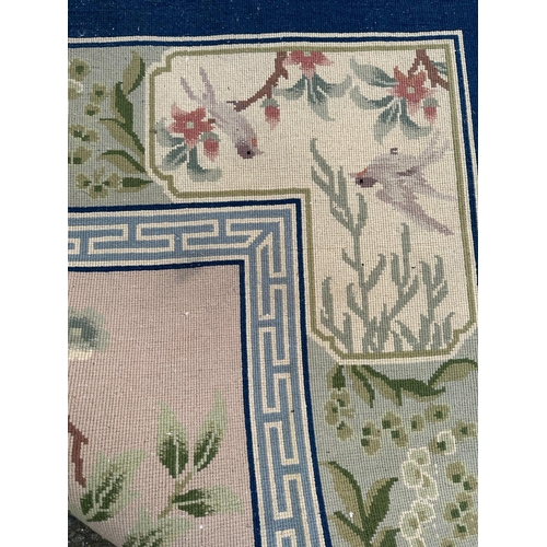 221 - A large Chinese style wool rug/carpet with pink grounds and geometric boarder  390cm x 270cm