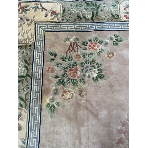 221 - A large Chinese style wool rug/carpet with pink grounds and geometric boarder  390cm x 270cm