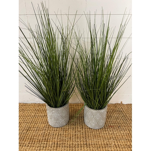 235 - A pair of faux grasses in pots