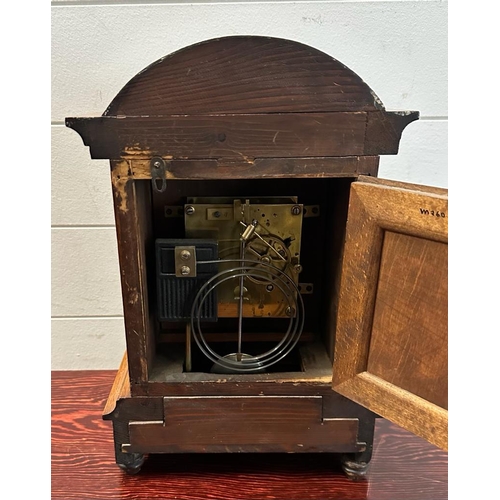 319 - An oak cased eight day mantel clock with brass face