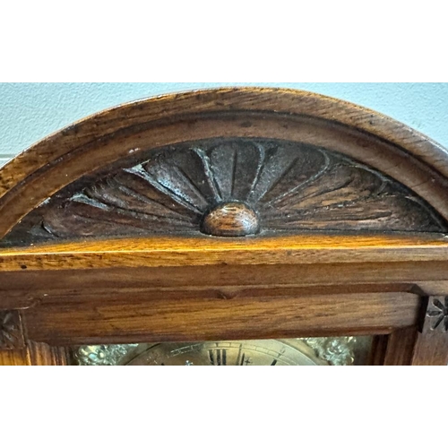 319 - An oak cased eight day mantel clock with brass face